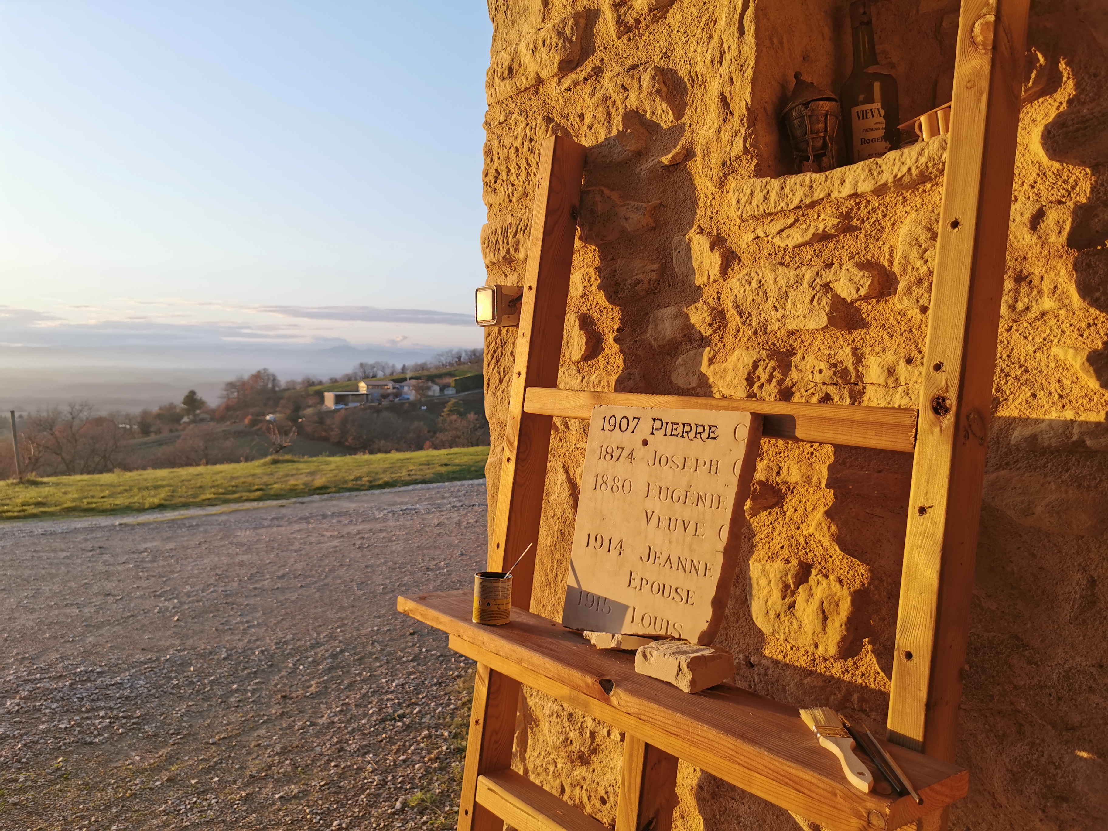 chevalet avec une plaque de marbre, un pot de peinture. etape de travail de peinture des lettres