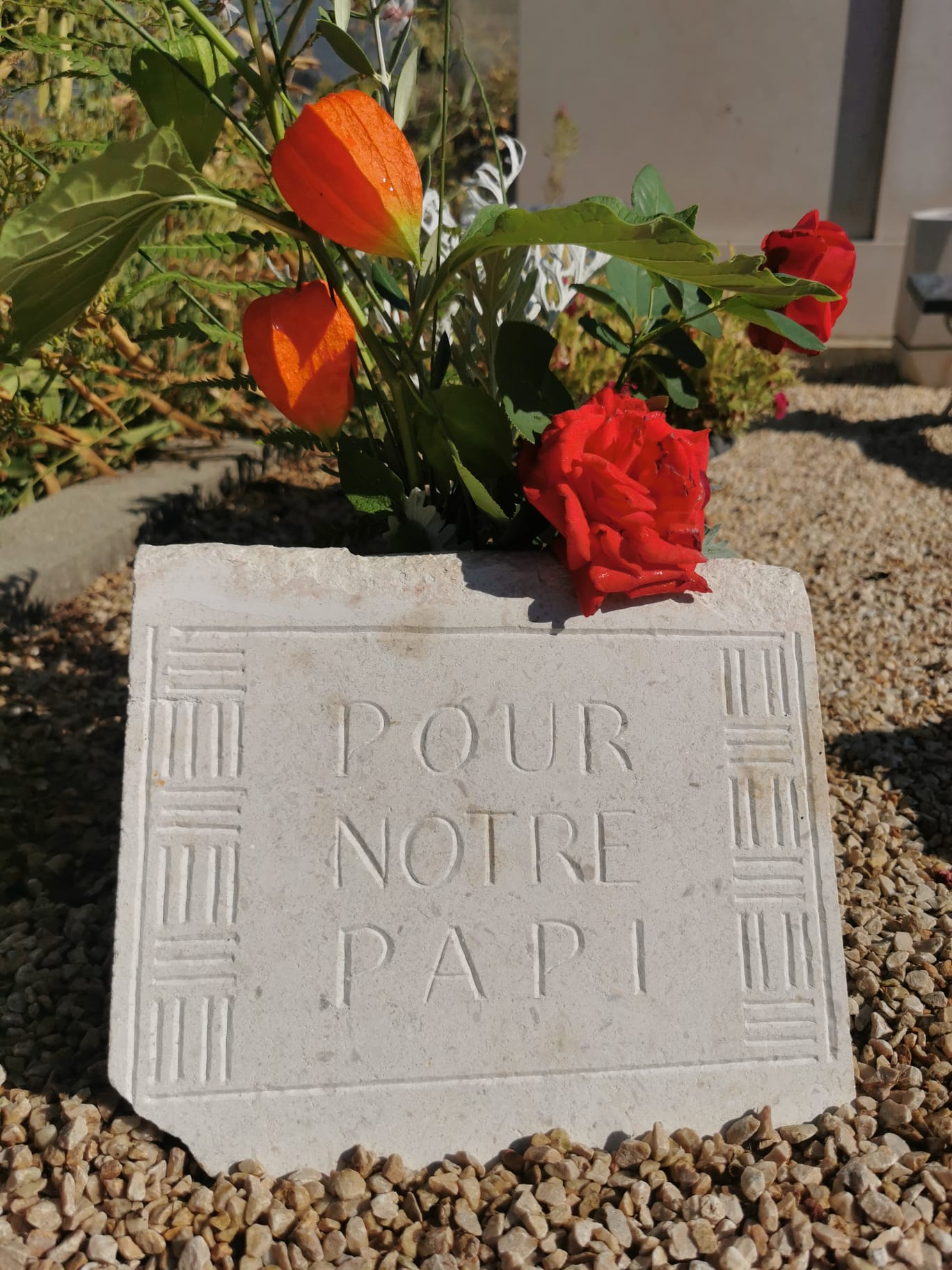 plaque de pierre blanche avec ornementations et gravures "A notre papi"