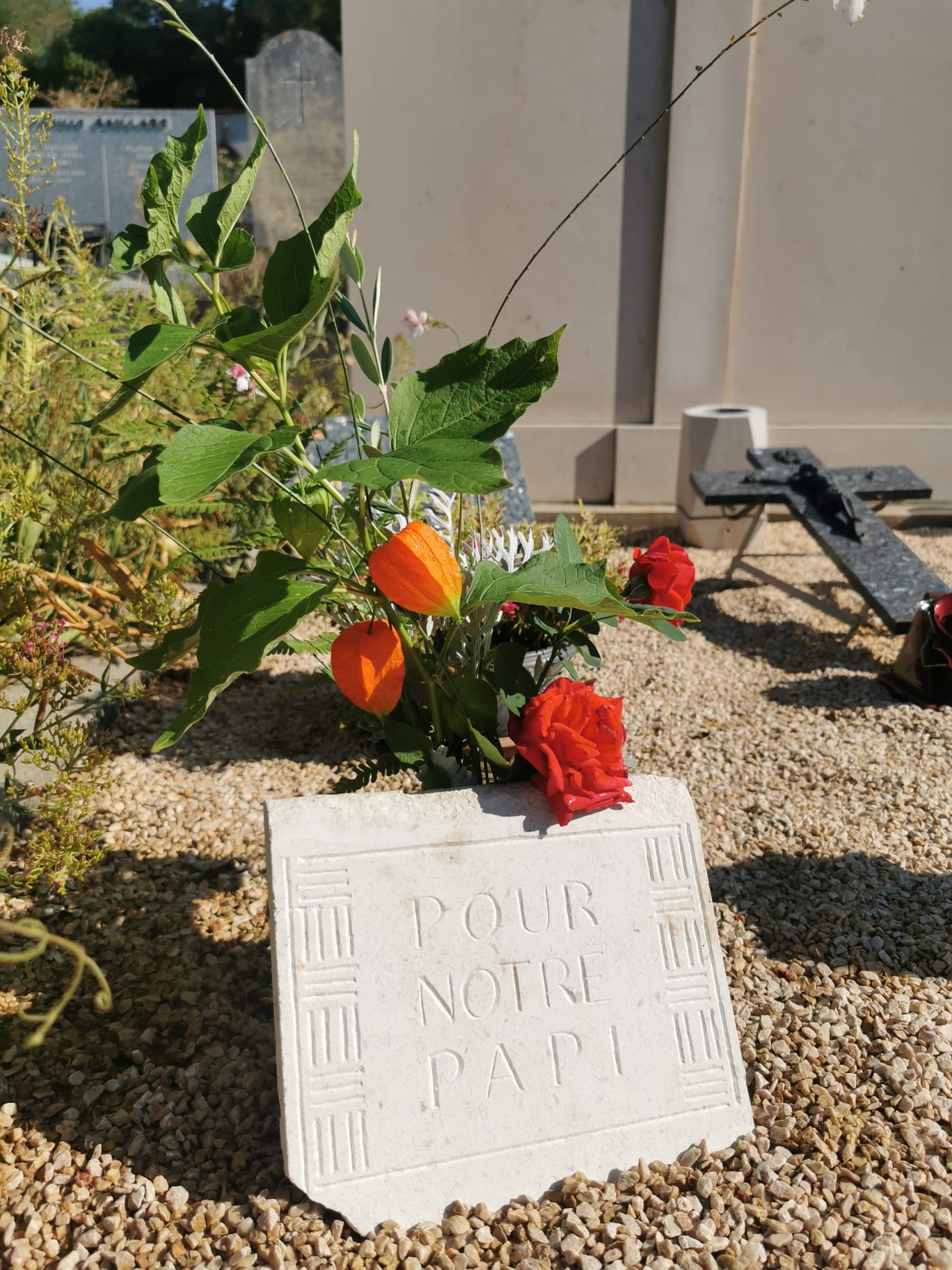 plaque de pierre blanche avec ornementations et gravures "A notre papi"